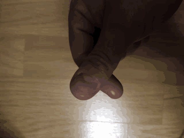 a close up of a person 's finger on a wooden table