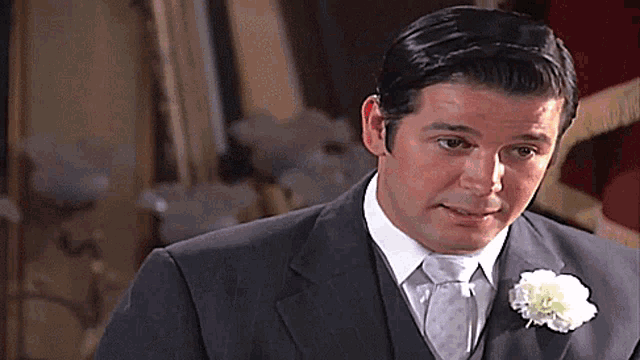a man in a suit and tie with a flower in his lapel