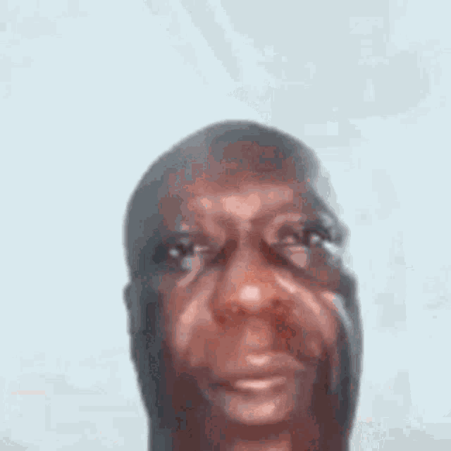 a close up of a man making a funny face with his mouth open and his eyes closed .