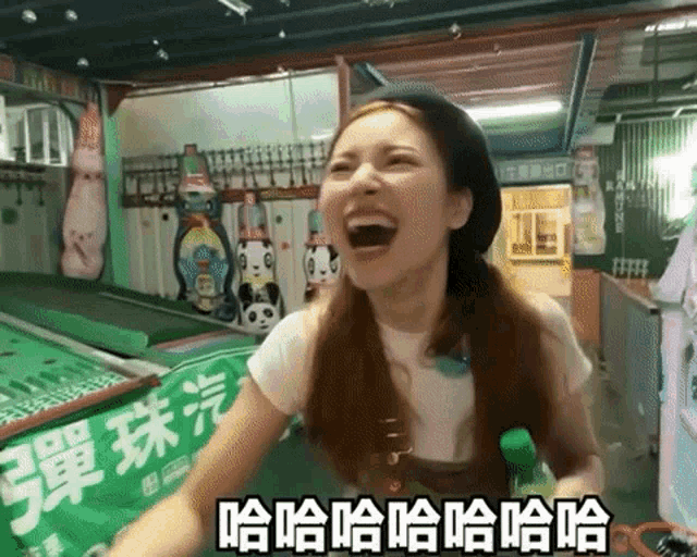 a woman is laughing while playing a game with chinese writing on the wall