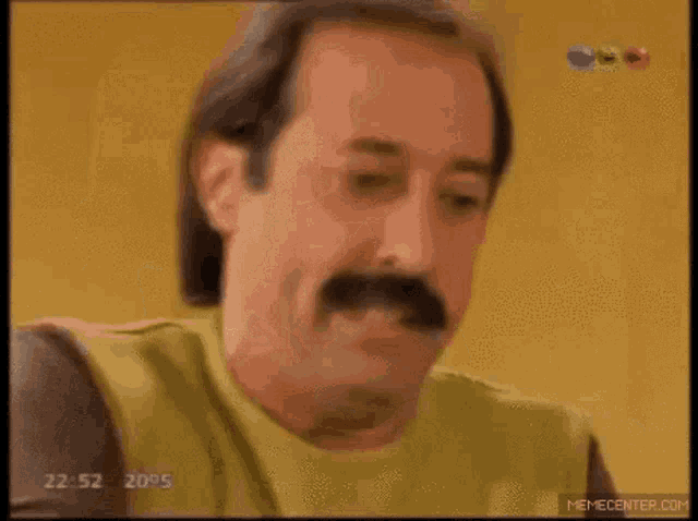 a man with a mustache is holding a napkin in his hand .