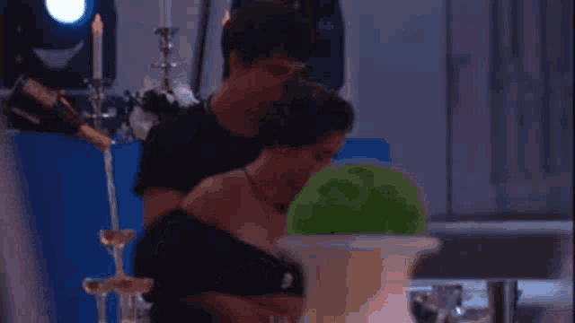 a man is holding a woman 's chest in a room with candles .