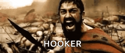 a man with a beard is holding a sword and screaming in a military battle .