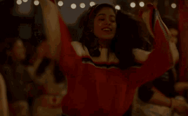 a woman is dancing in front of a crowd at a party and smiling .
