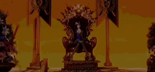 a man is sitting on a throne in a room .