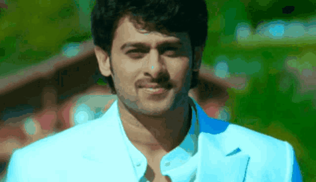 a man in a white shirt and blue jacket smiles