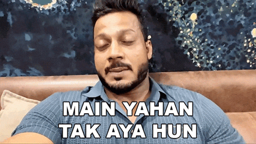 a man with a beard is sitting on a couch with the words main yahan tak aya hun below him