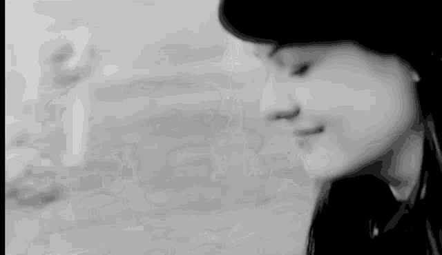 a black and white photo of a woman wearing a hat