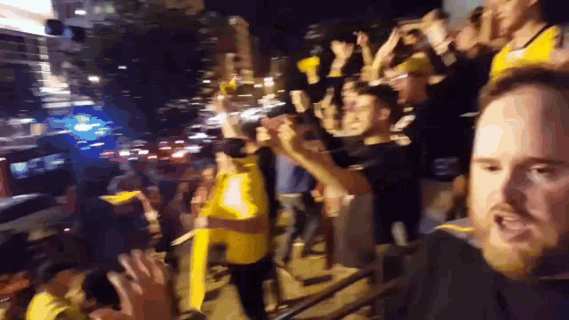 a blurry picture of a crowd of people including a man wearing a yellow shirt