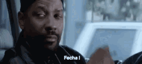 a man with a beard is sitting in a car and says fecha !