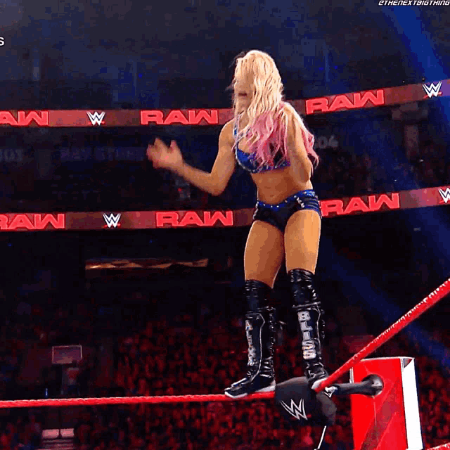a wrestler jumps over a rope with the word raw on it