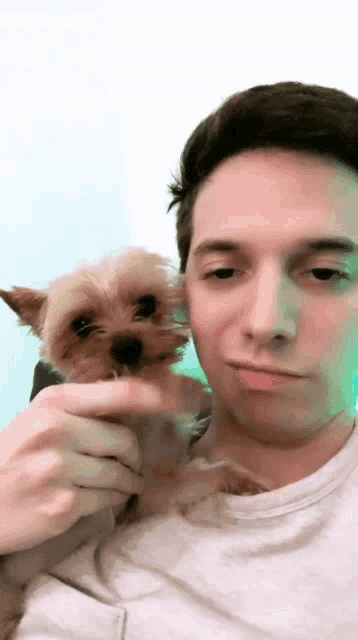 a man holding a small dog in his arms