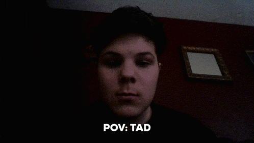 a man 's face is shown in a dark room with the words pov : tad above him