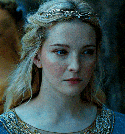 a close up of a woman wearing a blue dress and a tiara