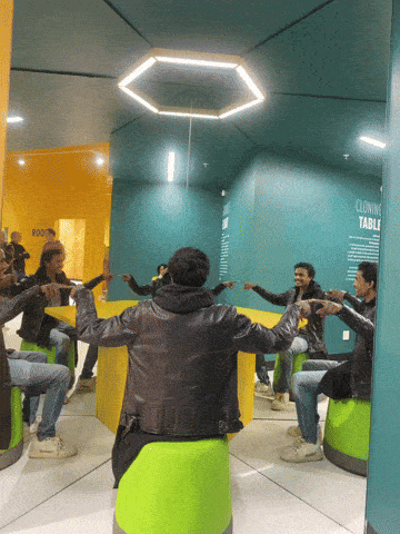 a group of people are sitting around a table in a room that says cloning table