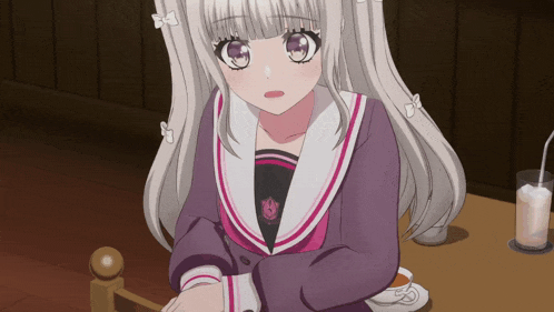 a girl with white hair is sitting at a table with a cup of milk