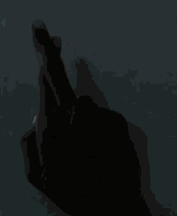 a close up of a person 's hand making a heart with their fingers .