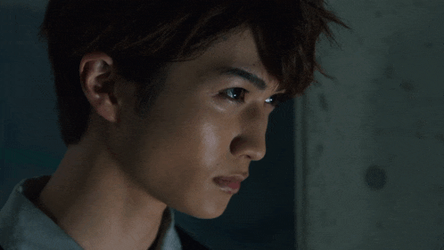 a close up of a young man 's face with a serious look on his face