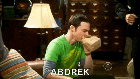 sheldon cooper from the big bang theory is sitting on a couch eating a bag of food .