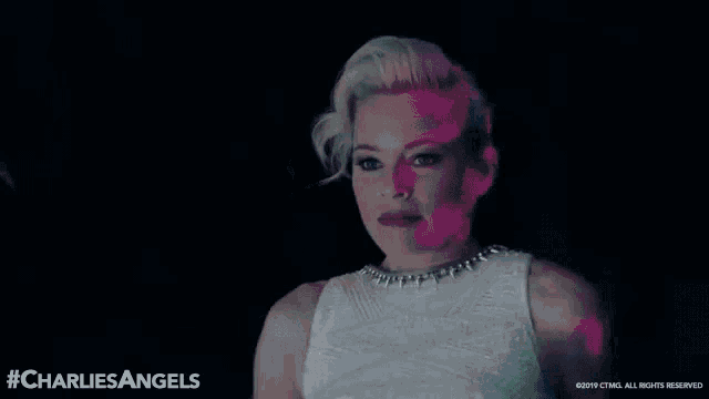 a woman 's face is projected onto a wall with the words charlie 's angels on the bottom