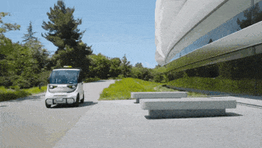 a small white vehicle with a license plate that says ' california ' on it drives down a road