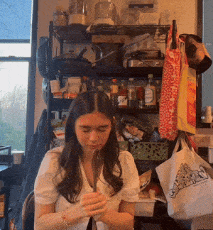 a woman sitting in front of a shelf with a bag that says ' a ' on it