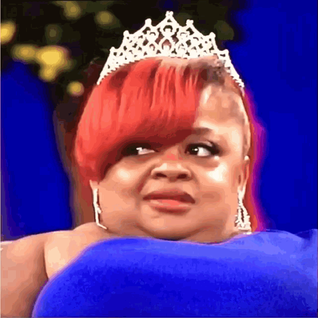 a woman with red hair is wearing a tiara on her head