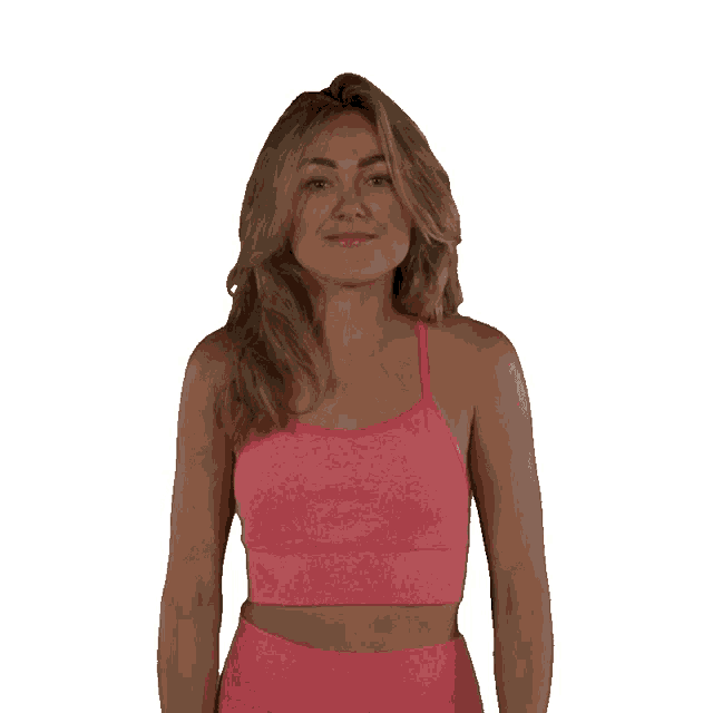 a woman in a pink top is clapping her hands in front of a white background