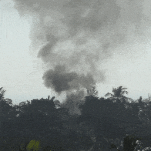 a large cloud of smoke is coming out of a building
