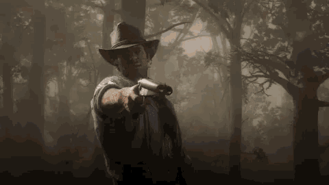 a man in a cowboy hat is holding a gun in the woods .