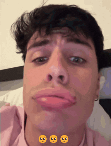 a man in a pink shirt is making a funny face with three smiley faces around his face