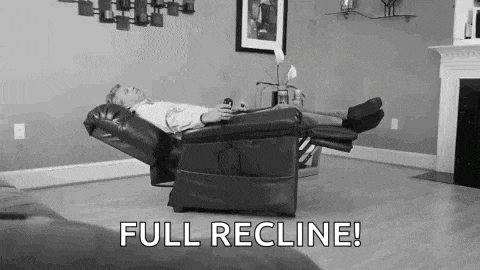 a man is laying in a recliner in a living room with the words `` full recline ! ''