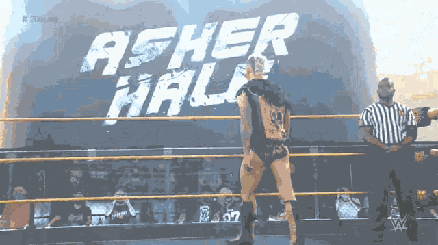 a wrestler in a ring with a sign that says acher hall