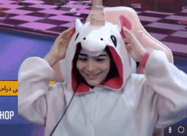 a woman is wearing a unicorn costume and smiling .