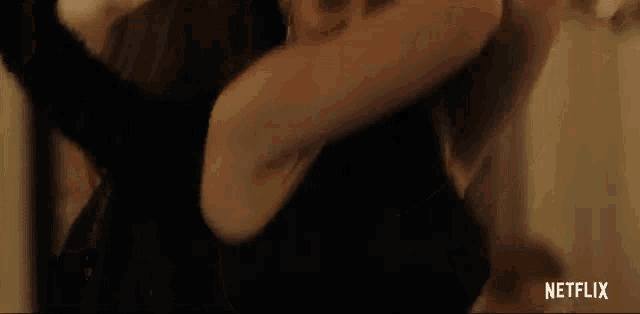 a woman in a black dress is dancing with a man in a dark room .
