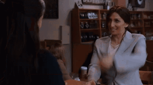 a woman in a suit is sitting at a table with another woman .
