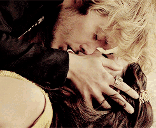 a man kissing a woman on the neck with a diamond ring on his finger
