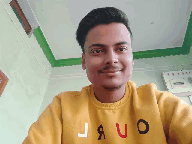 a man wearing a yellow sweater that says jauo on it