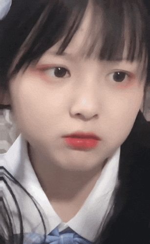 a close up of a young girl 's face with red lips