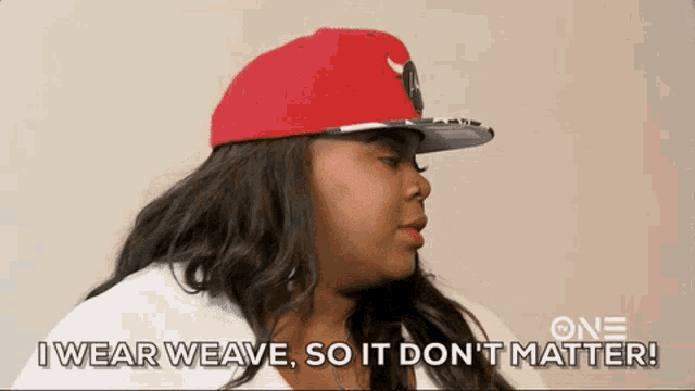 a woman wearing a red hat says " i wear weave so it don t matter "