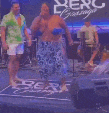 a woman in a floral dress is singing into a microphone on a stage