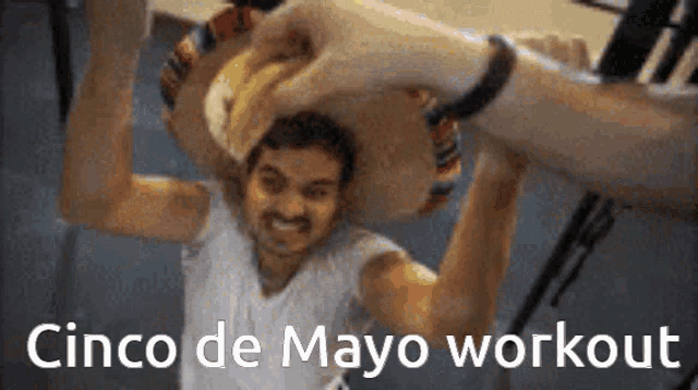 a man is holding a hot dog over his head with the words cinco de mayo workout written below him