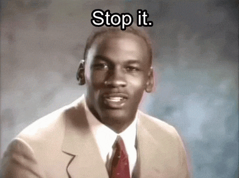 michael jordan is wearing a suit and tie and saying stop it .