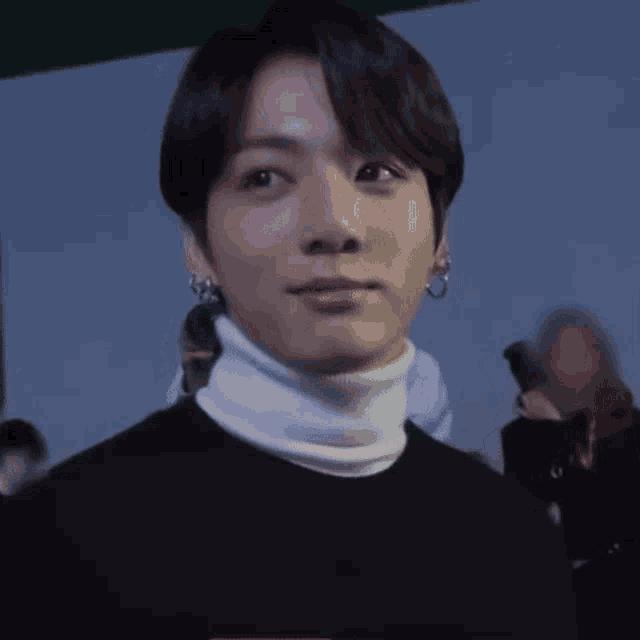 a close up of a person wearing a white turtleneck .