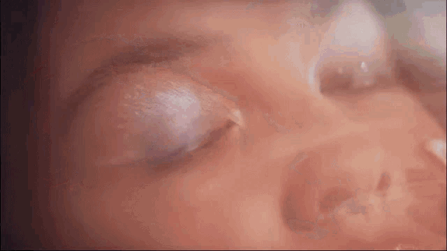 a close up of a woman 's face with a purple eyeshadow .