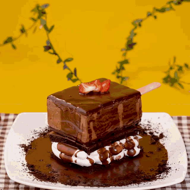 a piece of chocolate cake with a strawberry on top on a white plate