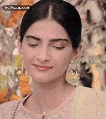 a close up of a woman with her eyes closed and smiling .