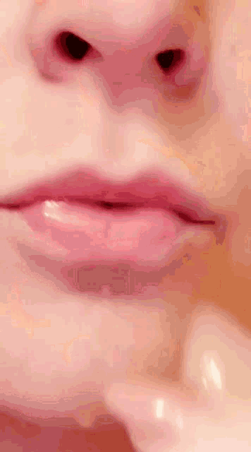a close up of a person 's face with a pink lip
