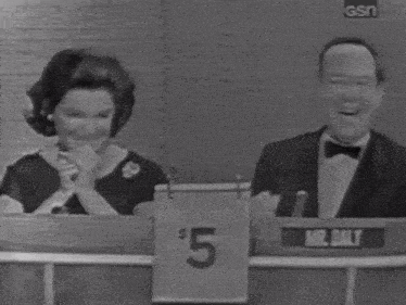 a man and a woman sitting at a table with a sign that says $ 5 on it