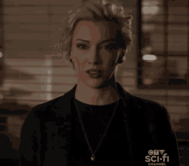 a woman is wearing a necklace and a jacket that says sci-fi channel on it